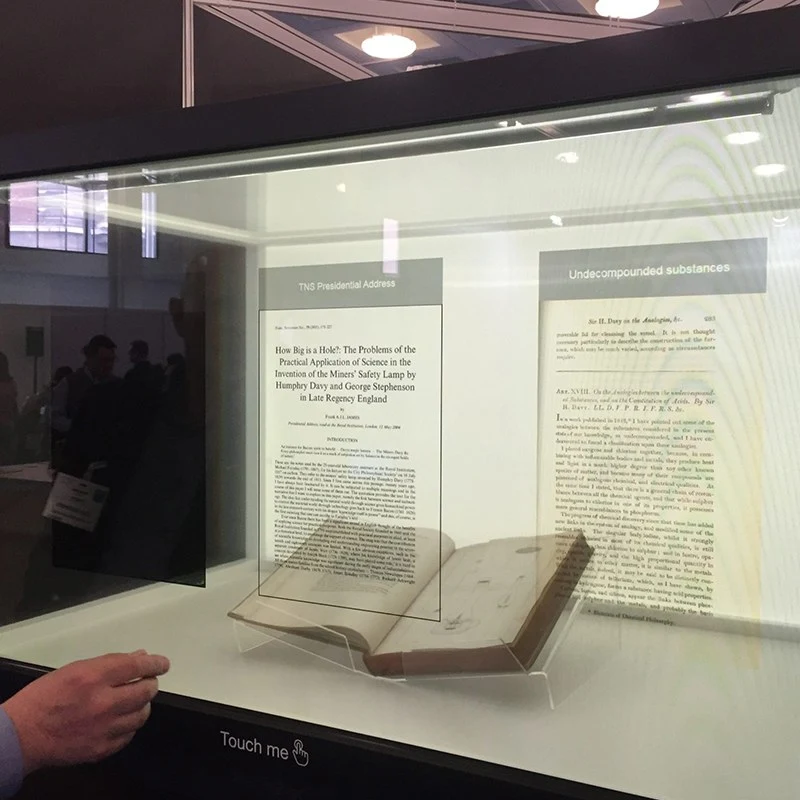 Smart museum display showcase with interactive digital text over a historical book